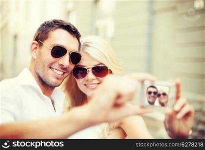 summer holidays and dating concept - couple taking photo in cafe in the city