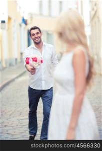 summer holidays and dating concept - couple with bouquet of flowers in the city. couple with flowers in the city