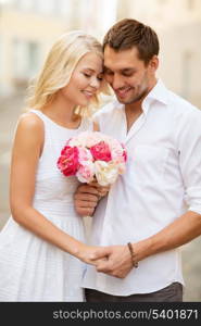 summer holidays and dating concept - couple with bouquet of flowers in the city