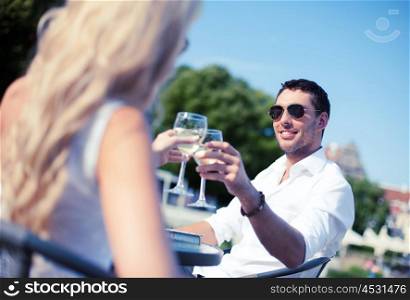 summer holidays and dating concept - man drinking wine with woman in cafe in the city. couple drinking wine in cafe