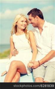 summer holidays and dating concept - smiling couple at sea side