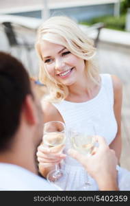 summer holidays and dating concept - woman drinking wine with man in cafe in the city