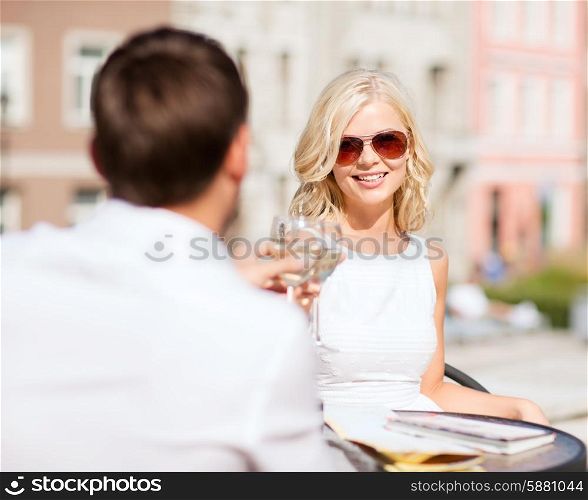 summer holidays and dating concept - woman drinking wine with man in cafe in the city