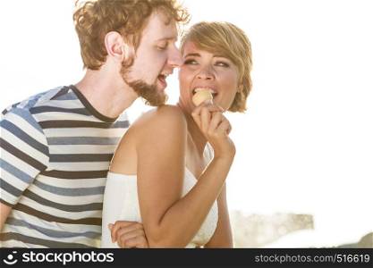 Summer holidays and happiness concept. Young couple eating ice cream outdoor city fountain in the background