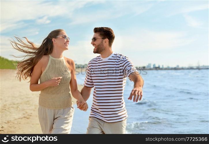 summer holidays and people concept - happy couple running along beach. happy couple running along summer beach