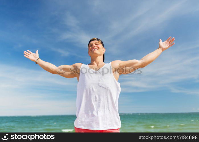 summer holidays and people concept - happy smiling young man on beach. smiling young man on summer beach