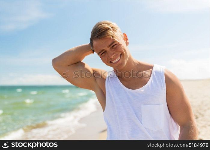 summer holidays and people concept - happy smiling young man on beach. smiling young man on summer beach