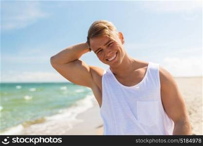 summer holidays and people concept - happy smiling young man on beach. smiling young man on summer beach