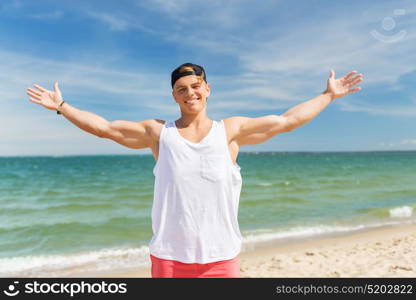 summer holidays and people concept - happy smiling young man on beach. smiling young man on summer beach