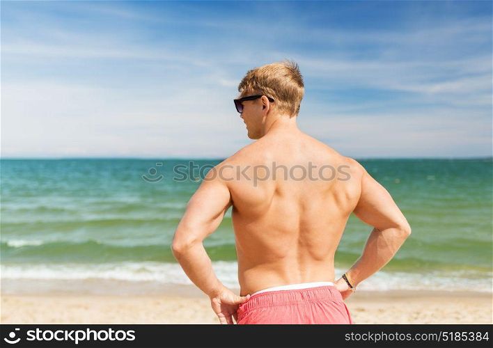 summer holidays and people concept - happy young man on beach. young man on summer beach