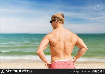 summer holidays and people concept - happy young man on beach. young man on summer beach