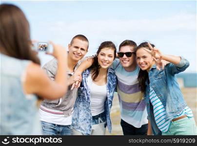 summer holidays and technology concept - group of teenagers taking photo outside. teenagers taking photo outside