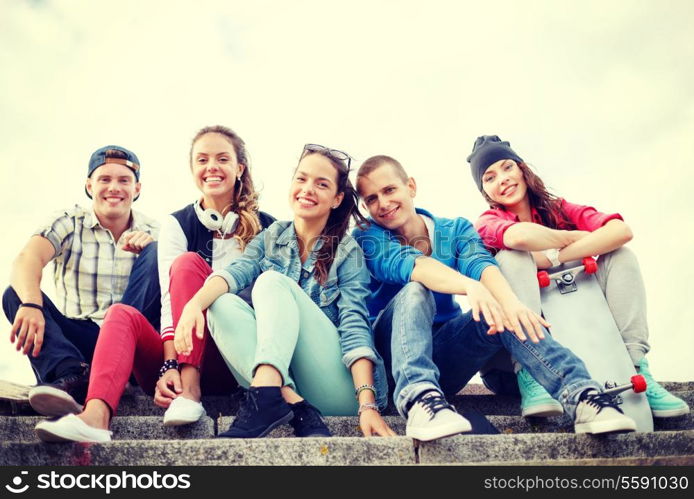 summer holidays and teenage concept - group of smiling teenagers hanging outside