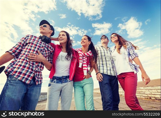 summer holidays and teenage concept - group of smiling teenagers in sunglasses hanging outside
