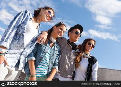 summer holidays and teenage concept - group of smiling teenagers in sunglasses hanging outside. smiling teenagers in sunglasses hanging outside