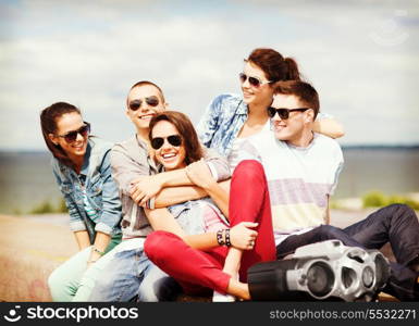 summer holidays and teenage concept - group of teenagers hanging out