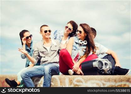 summer holidays and teenage concept - group of teenagers hanging out