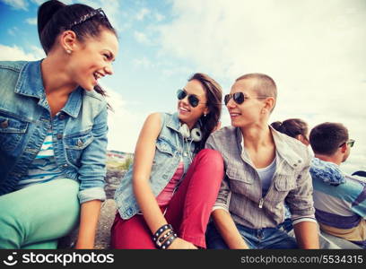 summer holidays and teenage concept - group of teenagers hanging out outside