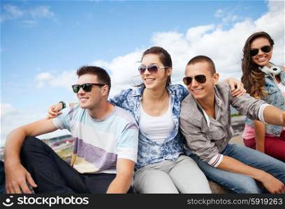 summer holidays and teenage concept - group of teenagers hanging out outside. group of teenagers hanging out