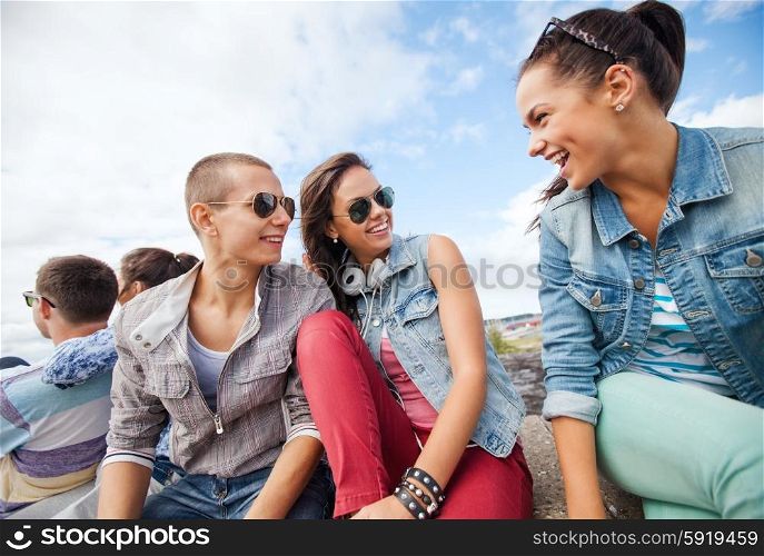 summer holidays and teenage concept - group of teenagers hanging out outside. group of teenagers hanging out