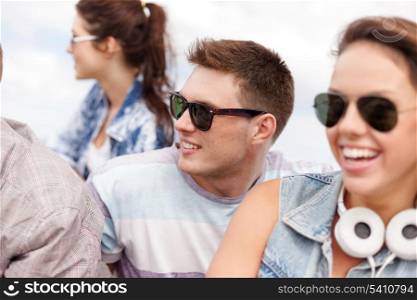 summer holidays and teenage concept - group of teenagers hanging outside