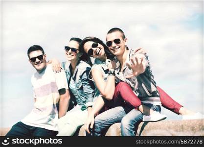 summer holidays and teenage concept - group of teenagers hanging outside