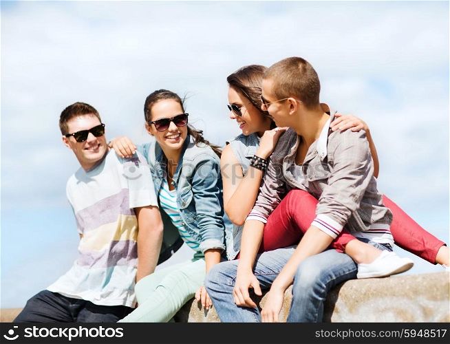 summer holidays and teenage concept - group of teenagers hanging outside. group of teenagers hanging out