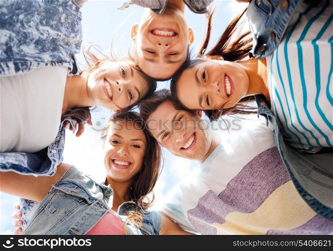 summer holidays and teenage concept - group of teenagers looking down