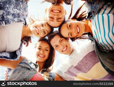 summer holidays and teenage concept - group of teenagers looking down