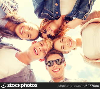 summer holidays and teenage concept - group of teenagers looking down