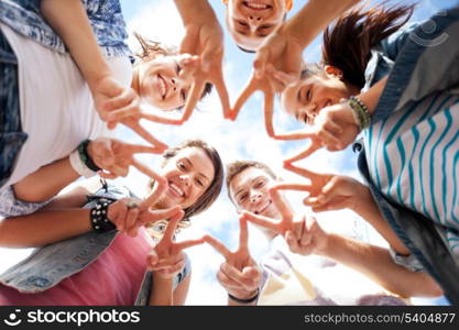 summer holidays and teenage concept - group of teenagers showing finger five gesture
