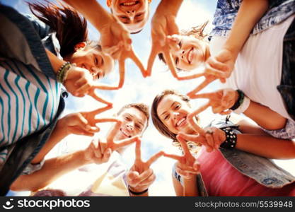 summer holidays and teenage concept - group of teenagers showing finger five gesture