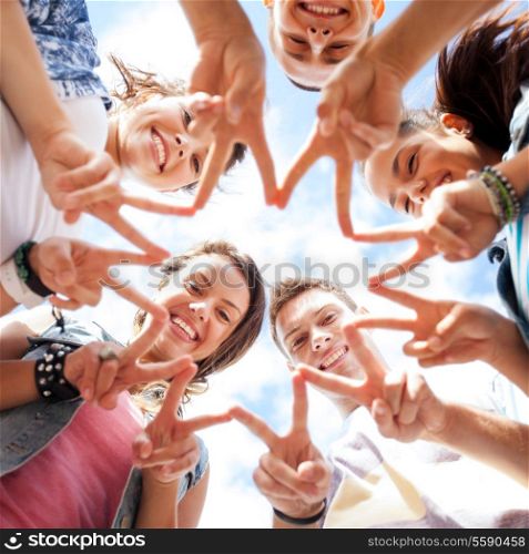 summer holidays and teenage concept - group of teenagers showing finger five gesture