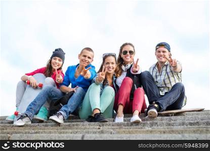 summer holidays and teenage concept - group of teenagers showing finger five gesture. group of teenagers showing finger five