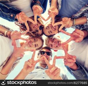 summer holidays and teenage concept - group of teenagers showing peace or victory gesture