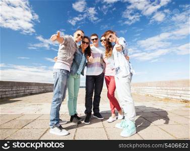 summer holidays and teenage concept - group of teenagers showing thumbs up