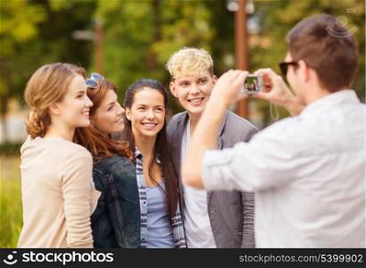 summer holidays and teenage concept - group of teenagers taking photo outside