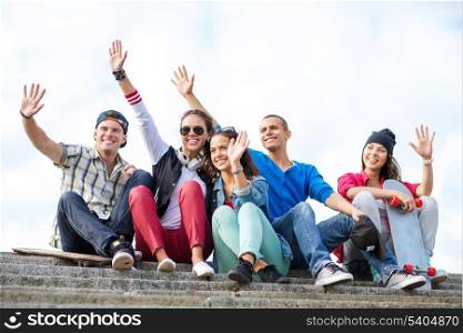 summer holidays and teenage concept - group of teenagers waving hands outside