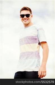 summer holidays and teenage concept - man in shades outside