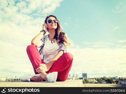 summer holidays and teenage concept - smiling teenage girl in sunglasses with headphones outdoors