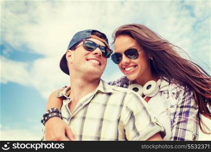 summer holidays and teenage concept - smiling teenagers in sunglasses having fun outside