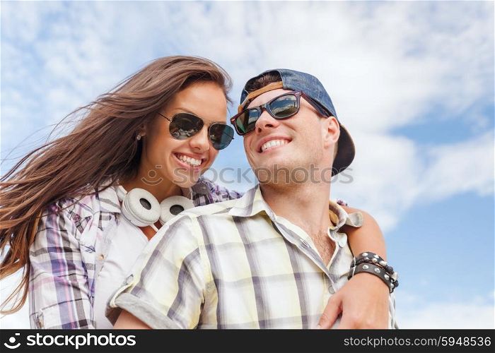 summer holidays and teenage concept - smiling teenagers in sunglasses having fun outside. smiling teenagers in sunglasses having fun outside