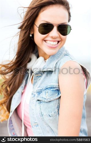 summer holidays and teenage concept - teenage girl in shades outside