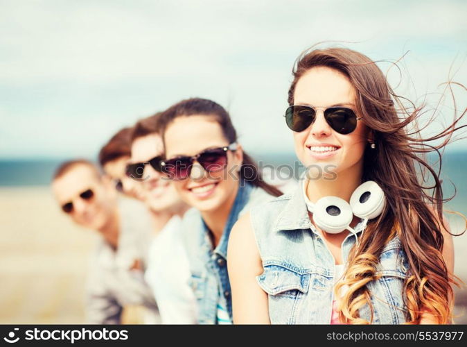 summer holidays and teenage concept - teenage girl with friends outside