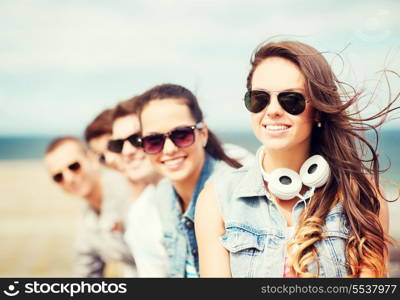 summer holidays and teenage concept - teenage girl with friends outside