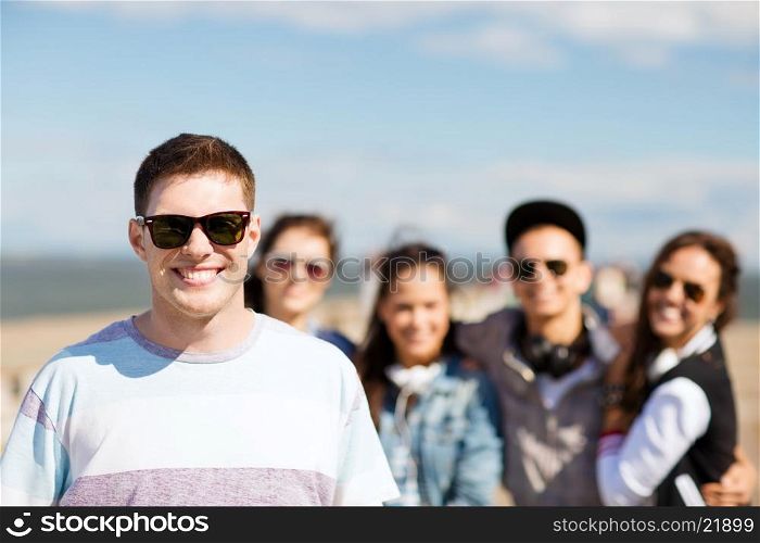 summer holidays and teenage concept - teenager in shades outside with friends. teenager in shades outside with friends