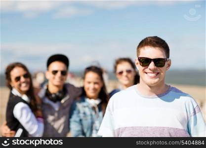 summer holidays and teenage concept - teenager in shades outside with friends