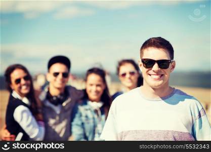 summer holidays and teenage concept - teenager in shades outside with friends