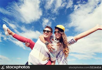 summer holidays and teenage concept - teenagers having fun outside