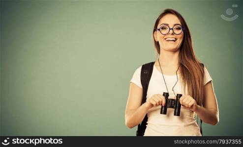 Summer holidays and tourism concept. Attractive woman long hair with backpack glasses holding binocular filtered photo
